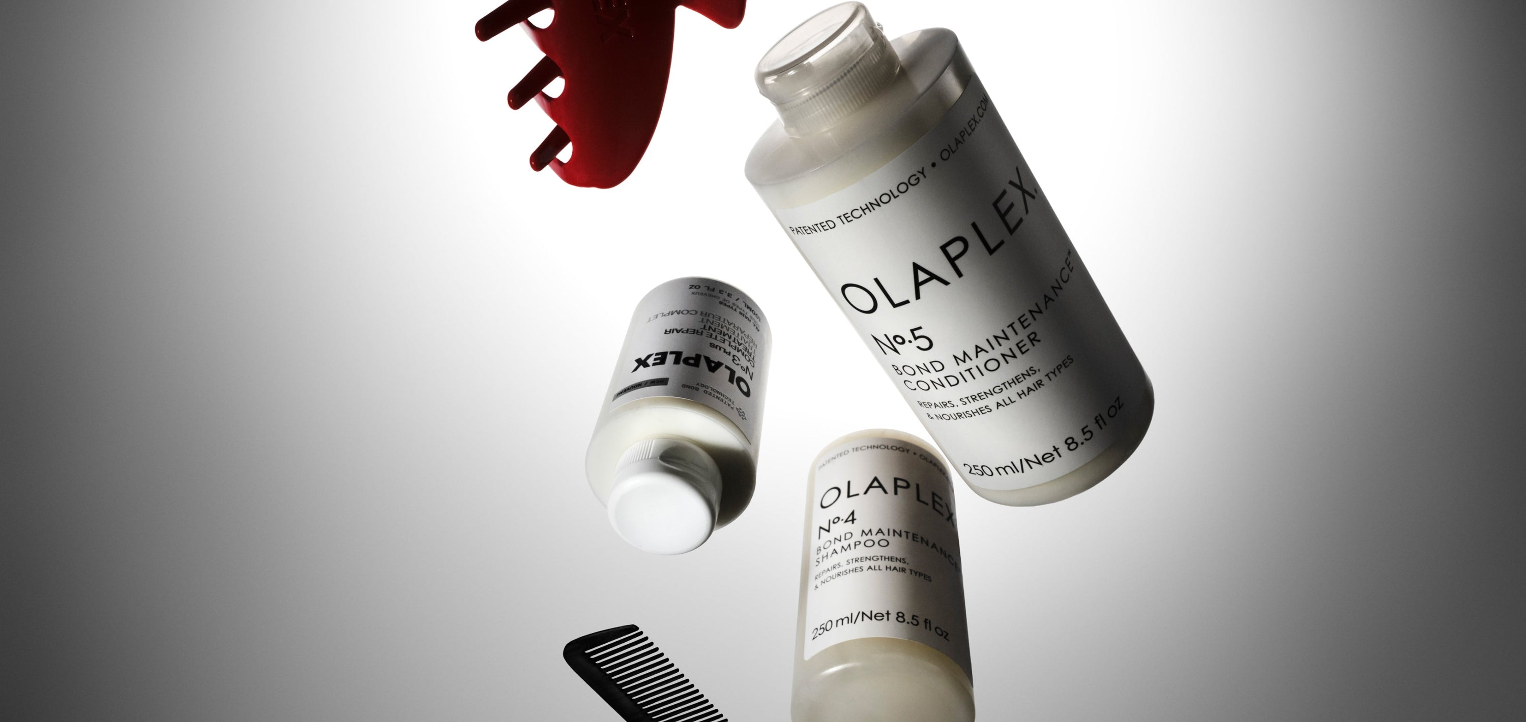 OLAPLEX No.3PLUs, No.4, and No.5 in various positions with a claw clip and a comb