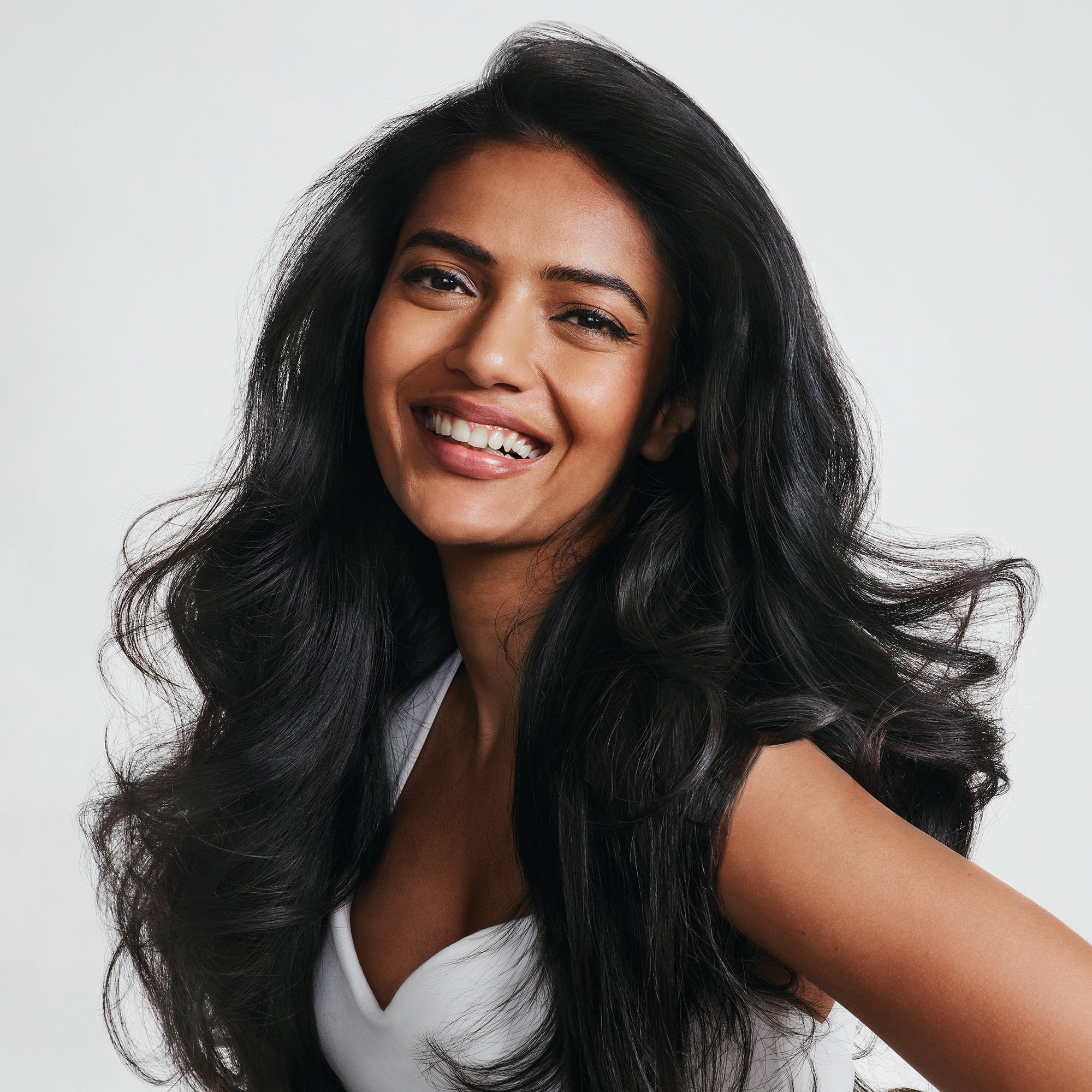 A woman with dark, thick hair smiling