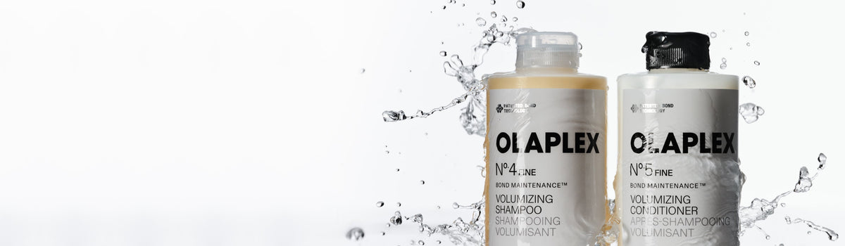 Shampoo and conditioner bottles with water splash in the background