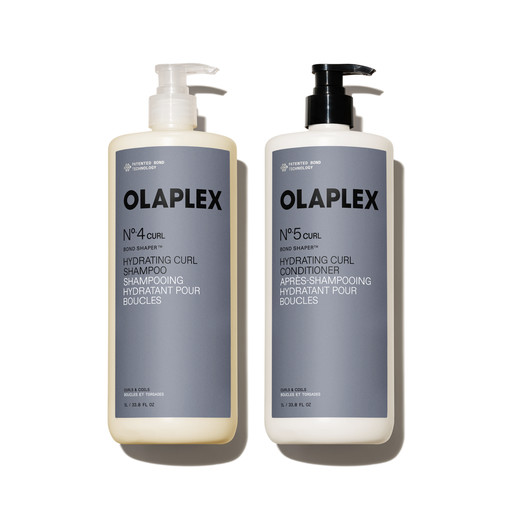 A liter-size set featuring OLAPLEX Nº.4CURL Bond Shaper Hydrating Curl Shampoo and Nº.5CURL Bond Shaper Hydrating Curl Conditioner. Both 1L / 33.8 fl oz bottles feature pump dispensers and are labeled for coils, curls, and waves. - main view